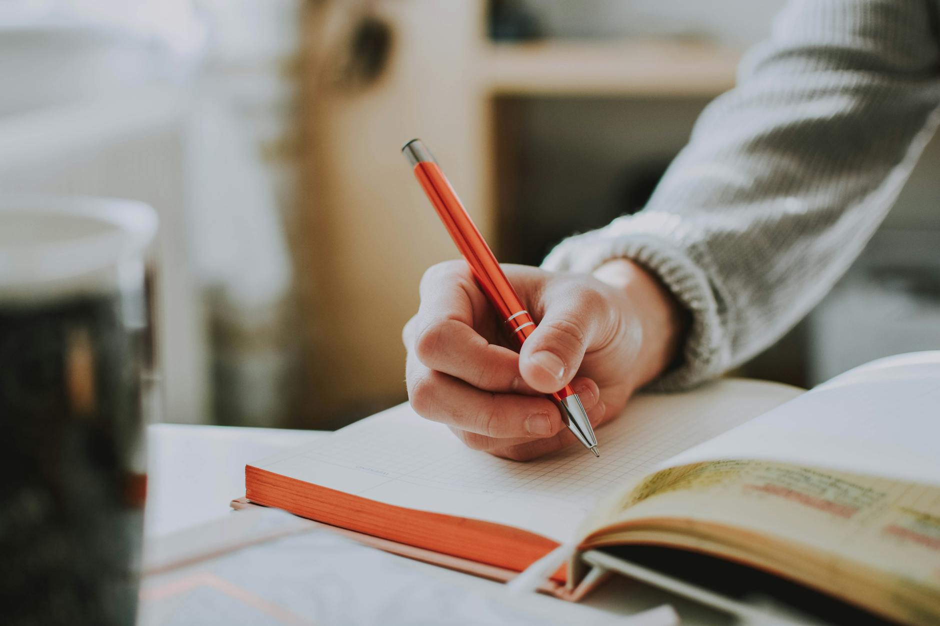 person holding orange pen